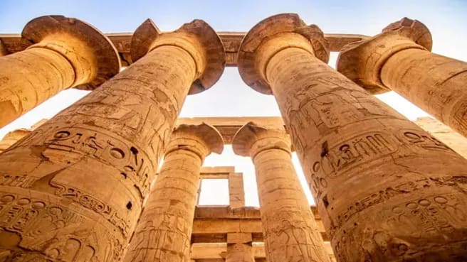 Ancient historical columns inside beautiful Egyptian landmarks with hieroglyphics.