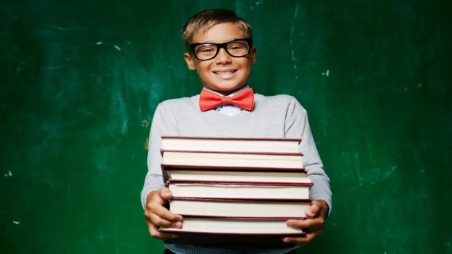 A smiling boy with many Literature books.