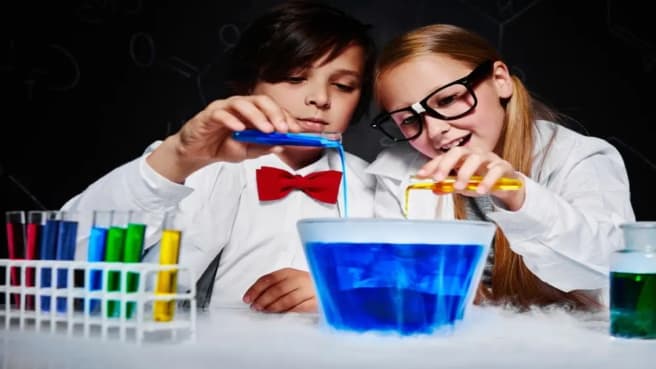 Two kids doing a small science experiment with blue liquid.