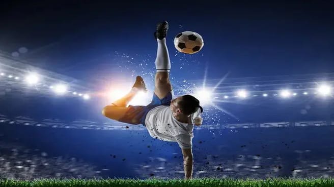 Soccer play kicking the ball in the air.