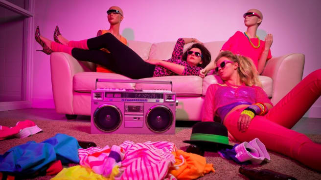 People dressed in 1980s style dresses with traditional 1980 stereo.