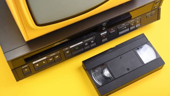 A television from the 1990s with a videotape cassette from the 1990s.