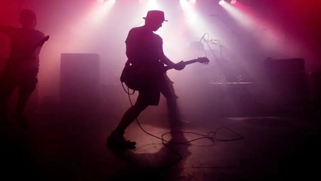 A 90s music played by a band with red lights on the stage.
