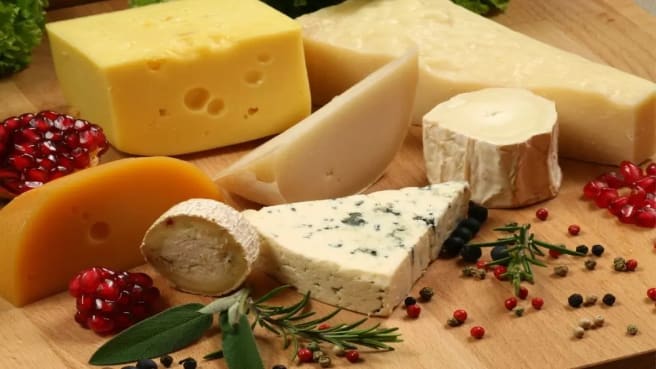 Few types of Cheese on a wooden desk.