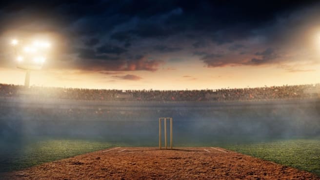 A Cricket stadium is full of a crowd of fans.