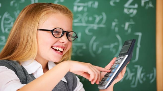 A smiling blonde girl solving easy math exercise.