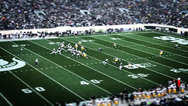 A Football court in an NFL game with many fans.