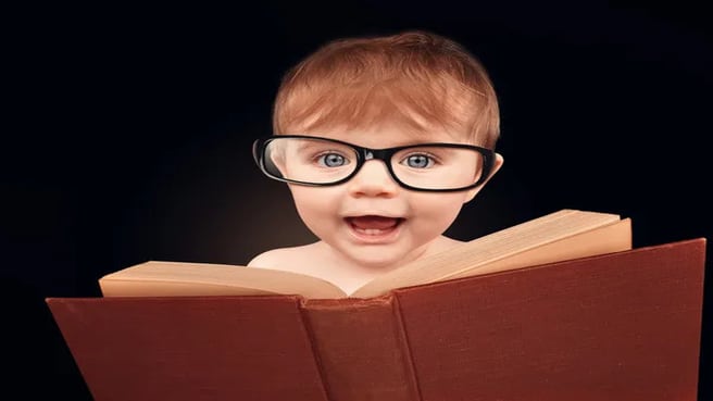 A cute little baby is wearing eye glasses and reading a library book for an education and general knowledge.