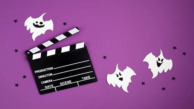A movie film clapperboard styled for Halloween with a purple background.