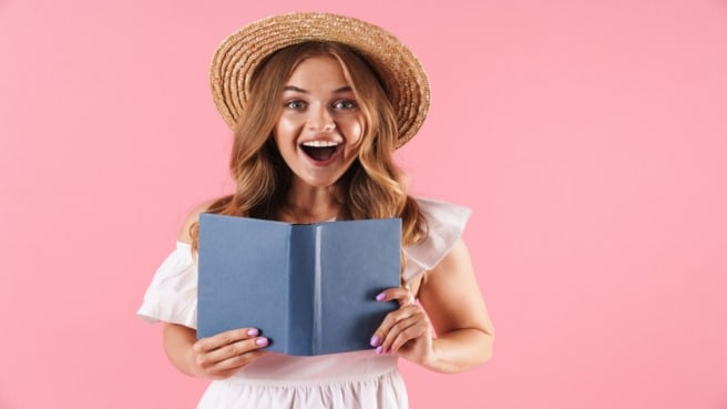 A woman that is reading Literature is surprised and happy.