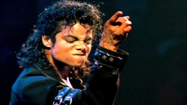 Michael Jackson dancing and singing during a live show.