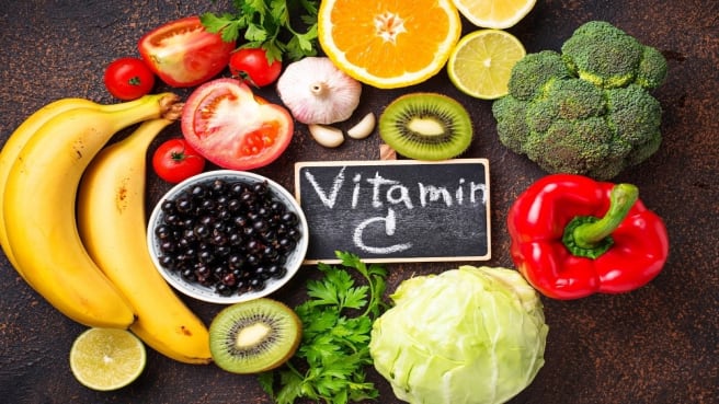 Food rich with Vitamin C & nutrients, and The words vitamin C are written on a chalkboard.