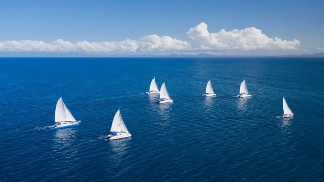 Beautiful clear blue Ocean with few ships with a white flag.