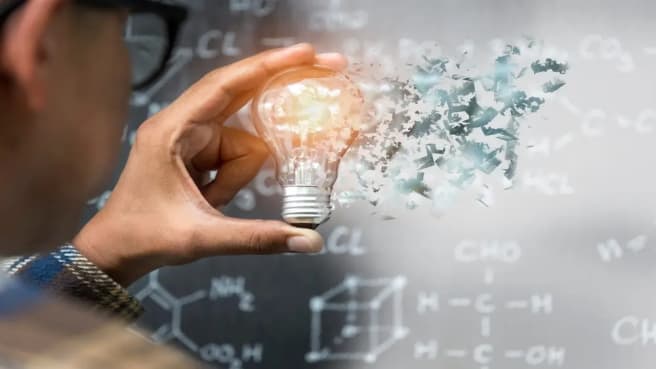 An hand holding a light bulb in a physics experiments.
