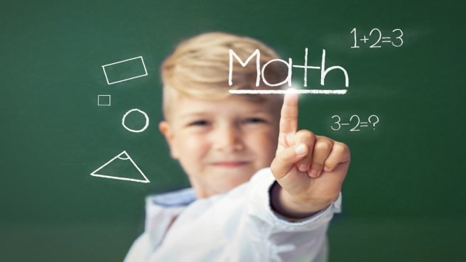 A kid with a math chalkboard pointing on the word Math.