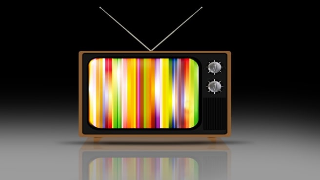 An old tv device on an old stool.
