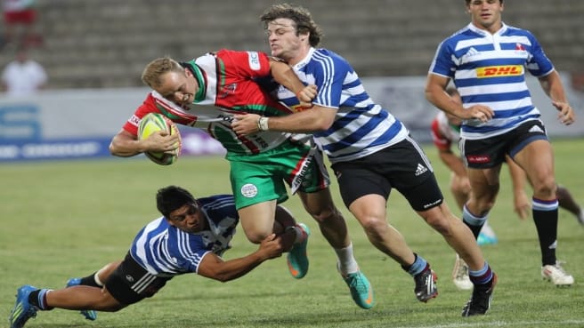 Four Rugby players are fighting on the ball during a rugby game.