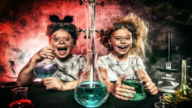 Funny school children doing science experiments in the laboratory.