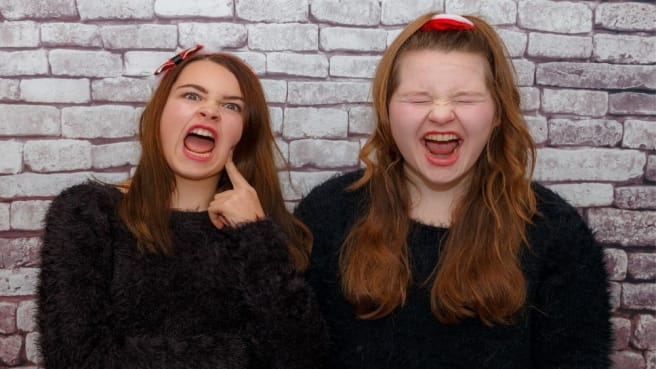 Two teenage girls doing funny faces.