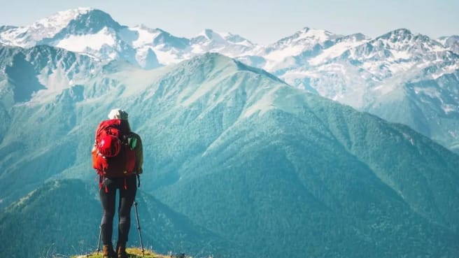 A woman travels on top of a snow mountain.