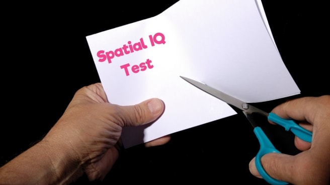 The spatial IQ test is being done by a woman that is cutting and folding a paper.