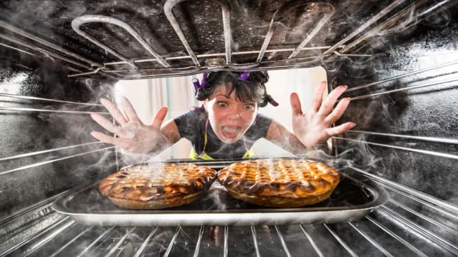 A funny woman looking at her burned food.