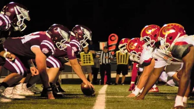 Two Football teams standing in a starting position