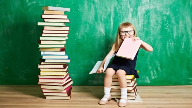 A funny girls reading literature, with many books around her.