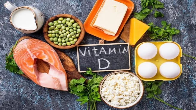 Food rich with Vitamin D & nutrients, and The words vitamin D are written on a chalkboard.