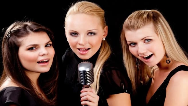 A pop music band of 3 girls singing.