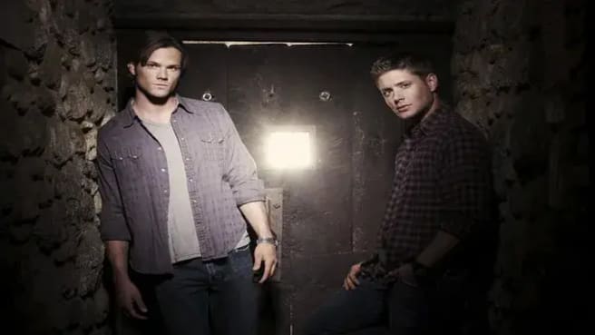 Jensen Ackles and Jared Padalecki (Supernatural) standing in an ancient corridor.