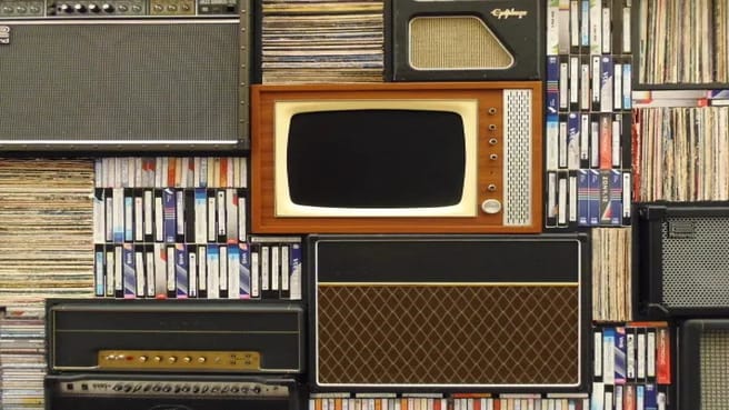 Old tv surrounded by books.