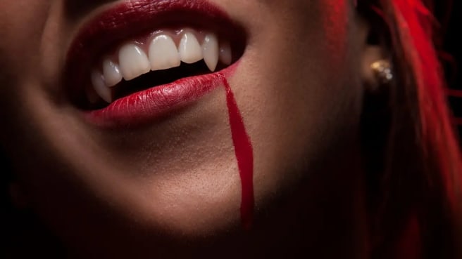 A woman vampire mouth with blood.
