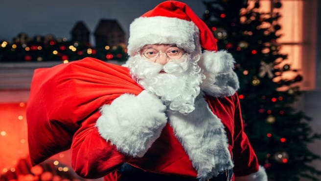 A funny Santa with Christmas presents in a bag.