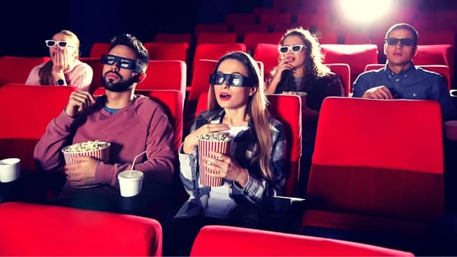 Funny people watch a movie in the cinema.