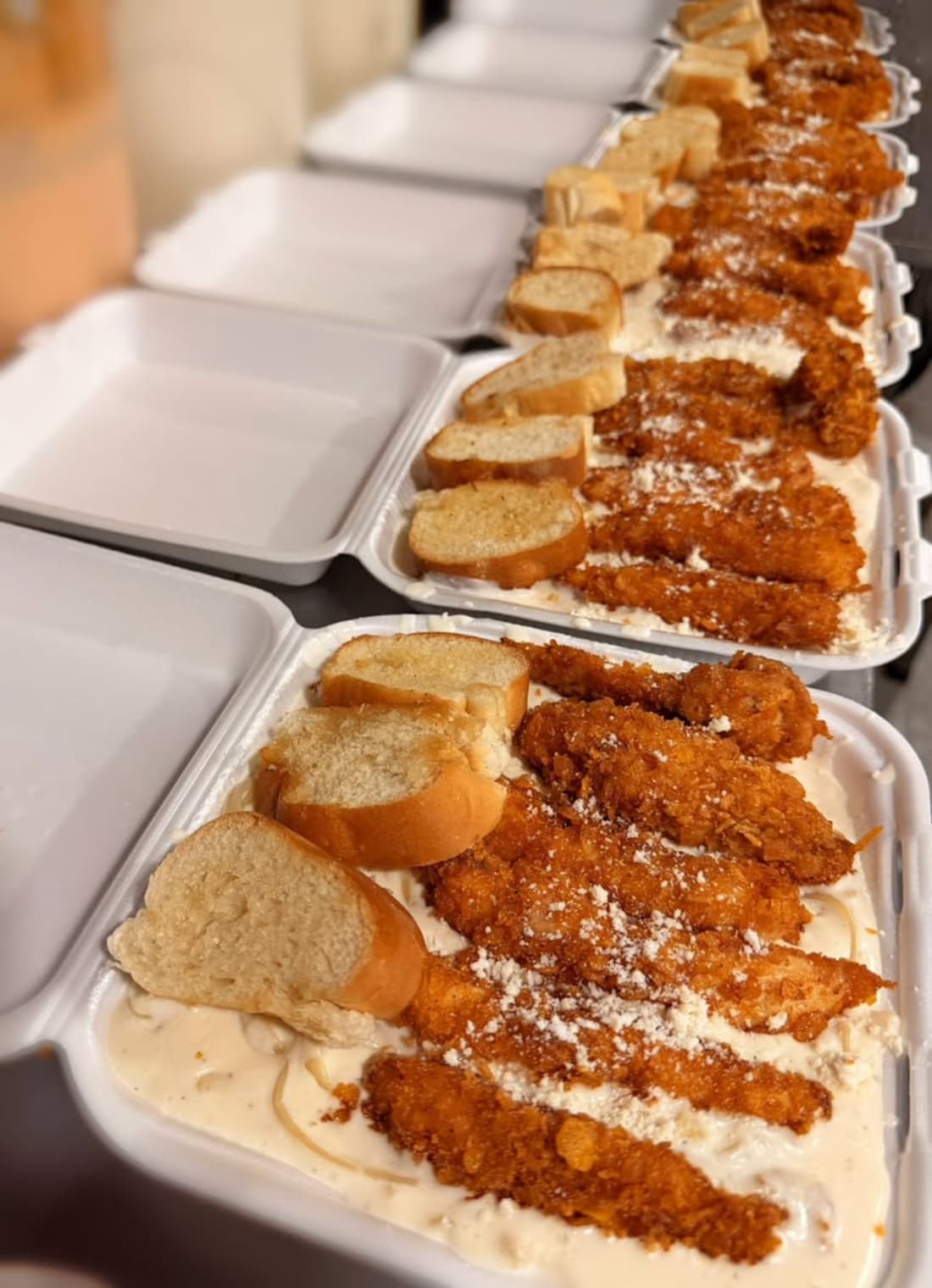 Bandejas con postres fritos, pan tostado y crema. Comida preparada en recipientes desechables.
