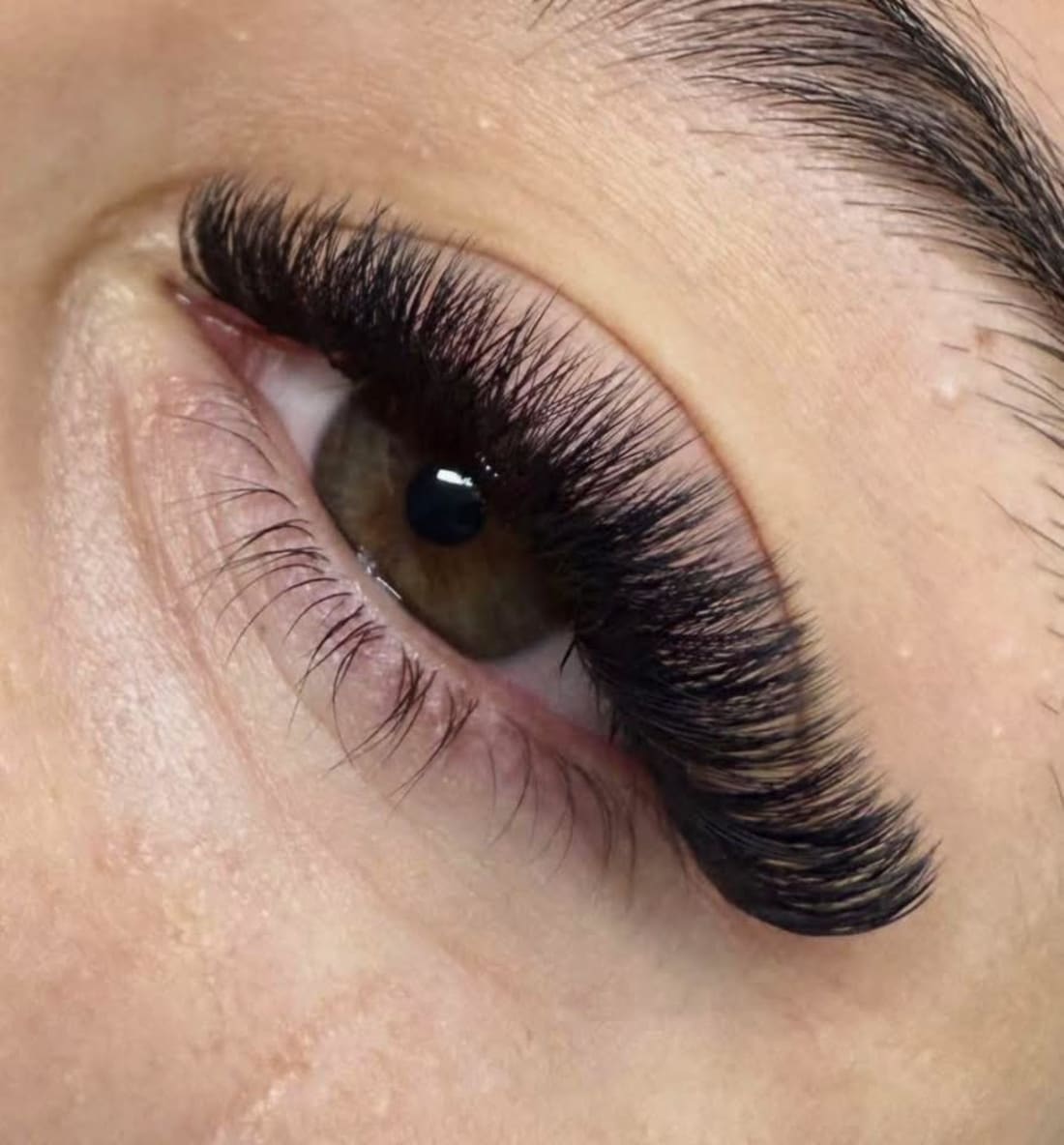 Ojo de mujer con pestanas postizas negras largas. Trabajo de extension de pestanas.