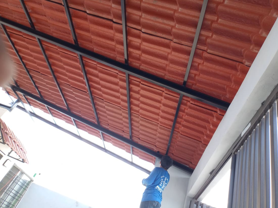 Techo corrugado rojo con estructura metálica persona trabajando.