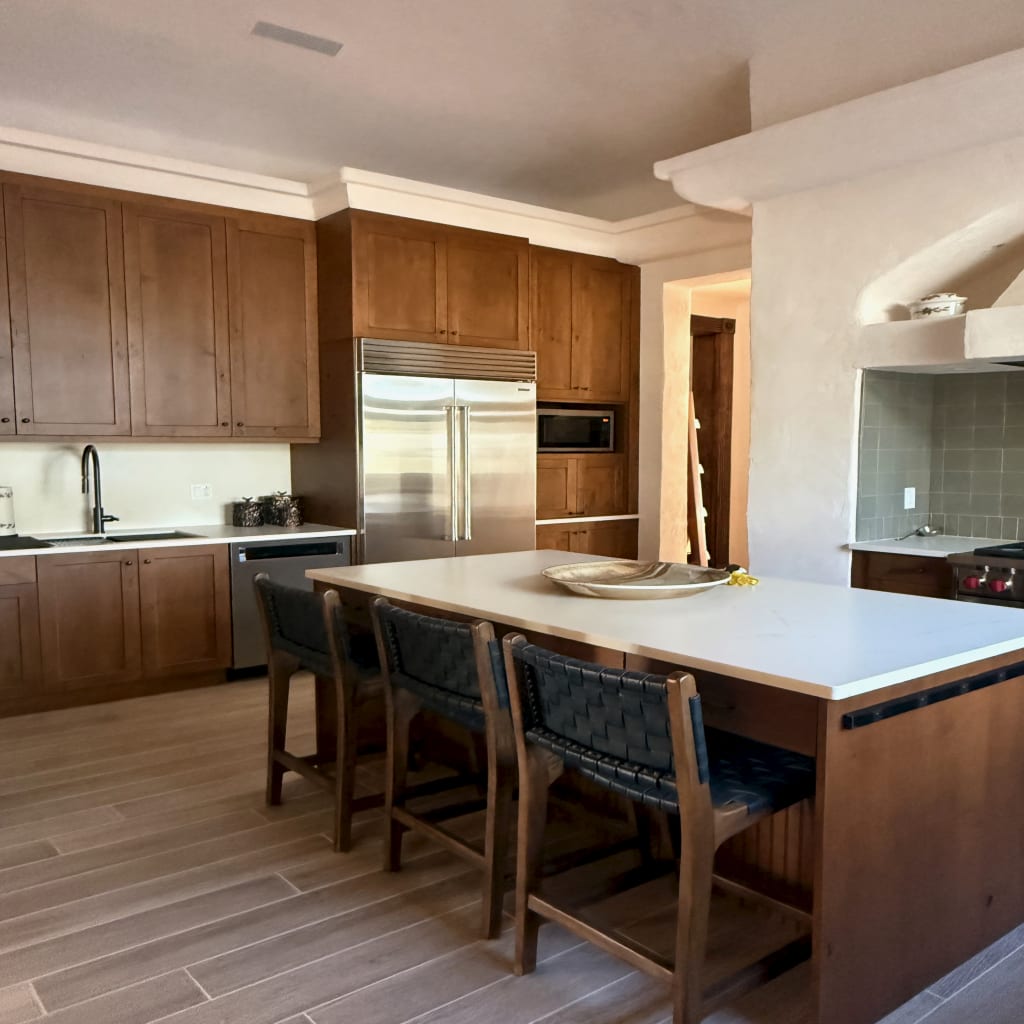 Warm custom kitchen with island seating and integrated appliances