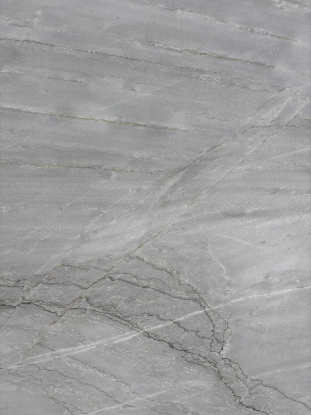 Azurra Bay quartzite block 4047 detail, soft grey ground with fine diagonal grey veining under a honed finish