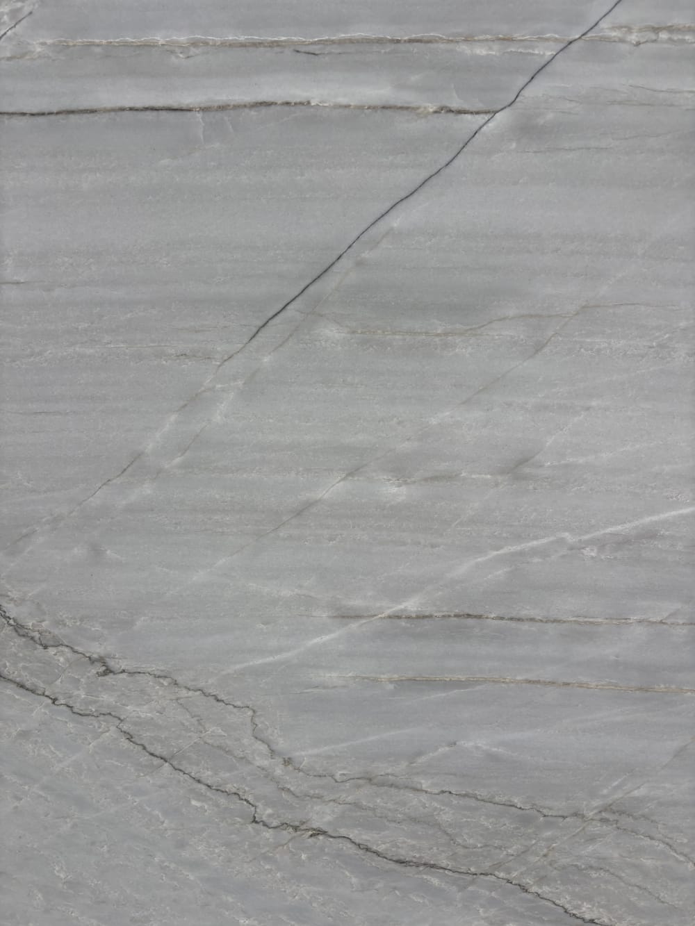Azurra Bay quartzite block 4047 detail, fine grey veins crossing a pale grey honed surface