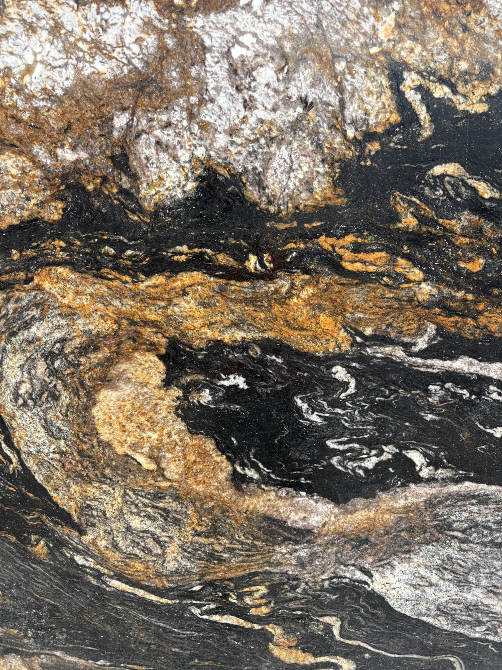 Magma granite detail, a molten band of gold between black and silver-white