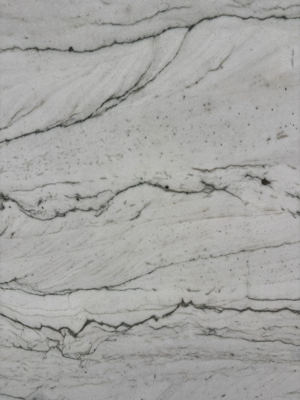 Opus quartzite detail, soft honed and brushed surface with drifting dark grain