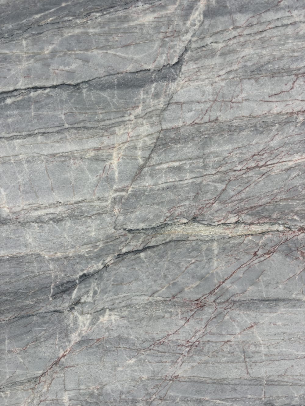 Essenza Blue quartzite block 13879 detail, honed surface with directional grey banding and hair-fine red veins
