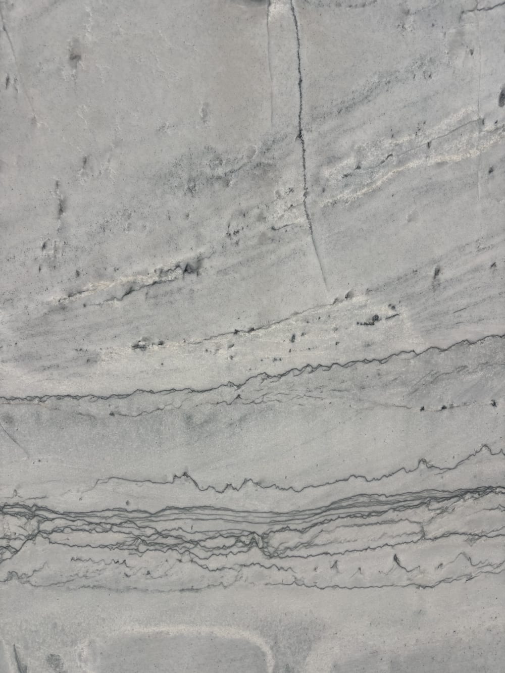 Maldives quartzite detail, layered grey banding stacked in fine horizontal seams
