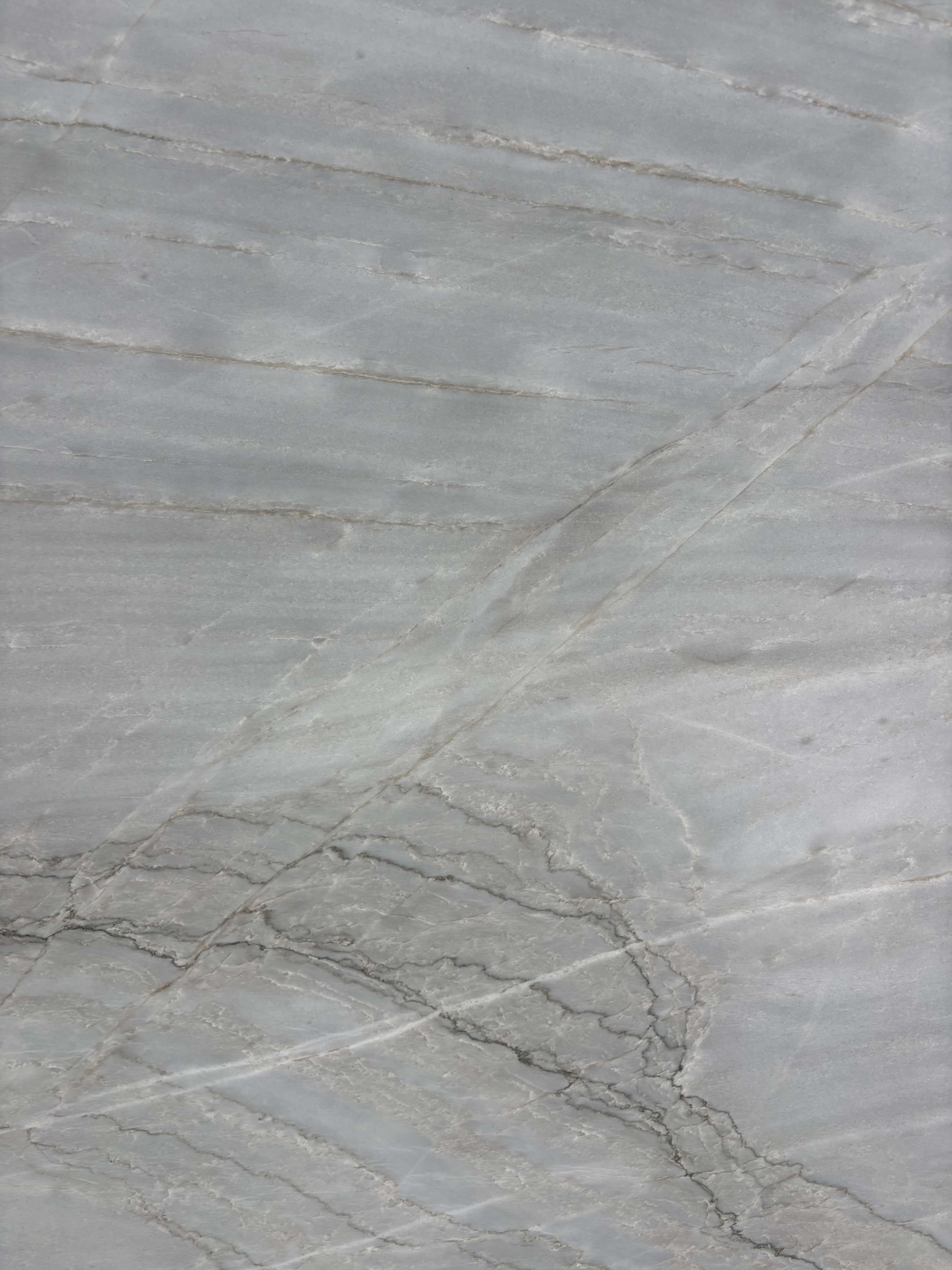 Azurra Bay quartzite block 4047 detail, soft grey ground with fine diagonal grey veining under a honed finish