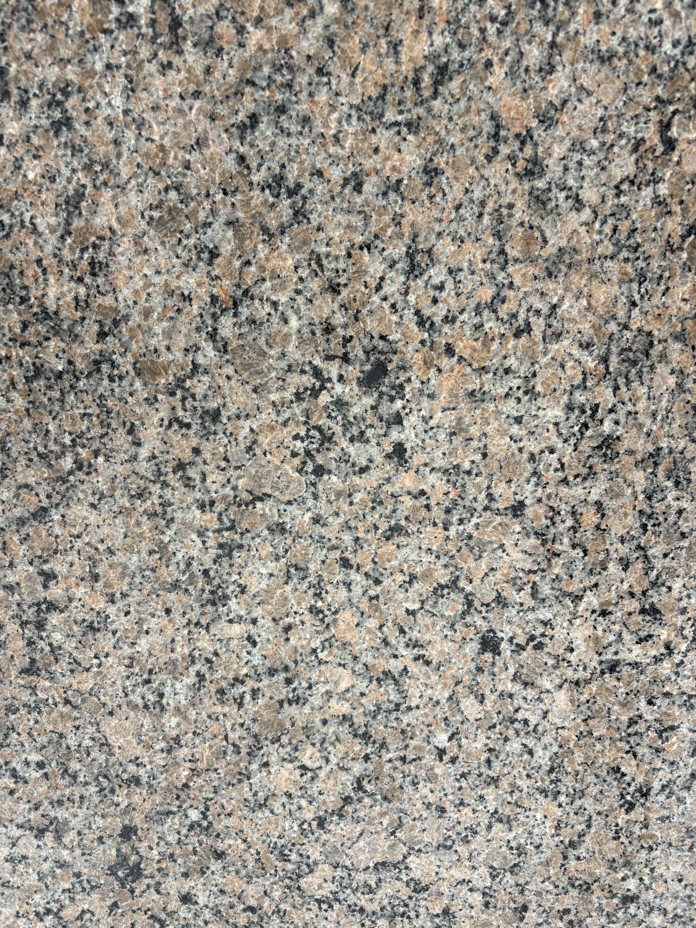 Giallo Latina granite block 758 detail, beige and pale pink ground with a tight black and grey speckle under a polished finish