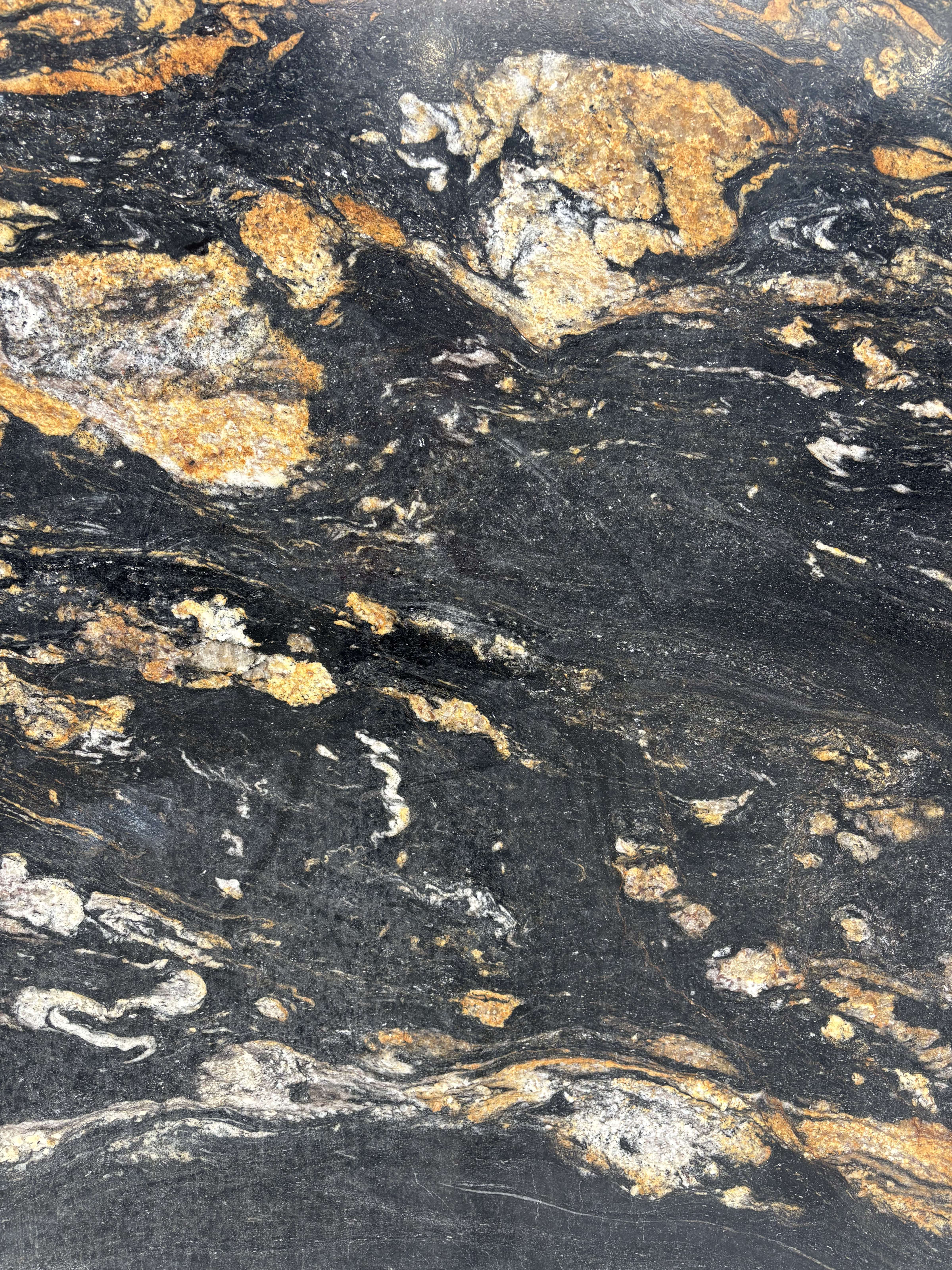 Magma granite detail, gold and amber clusters across a black crystalline ground