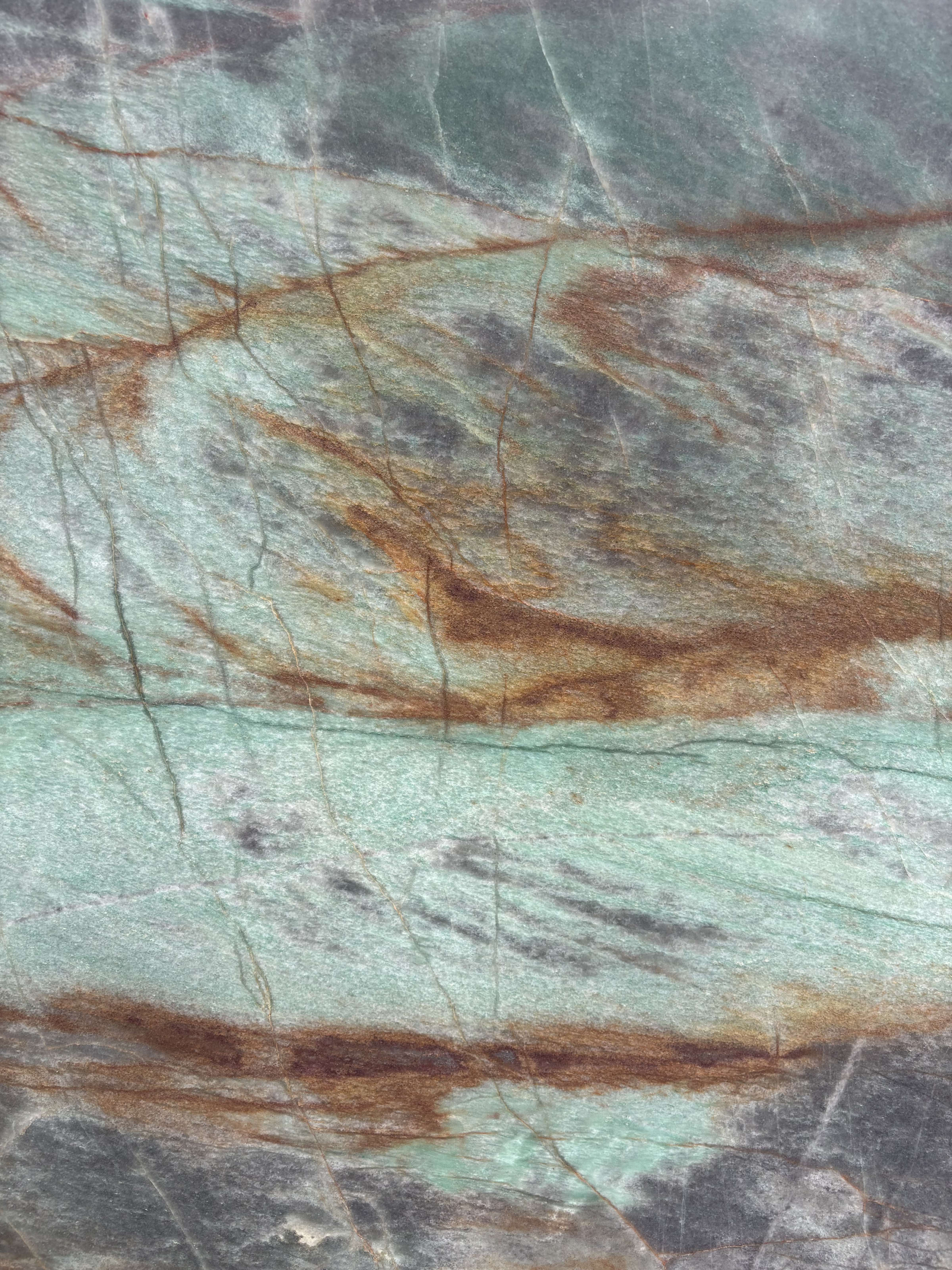 Sauipe quartzite detail, emerald-green ground with rich copper veining pooling across the surface