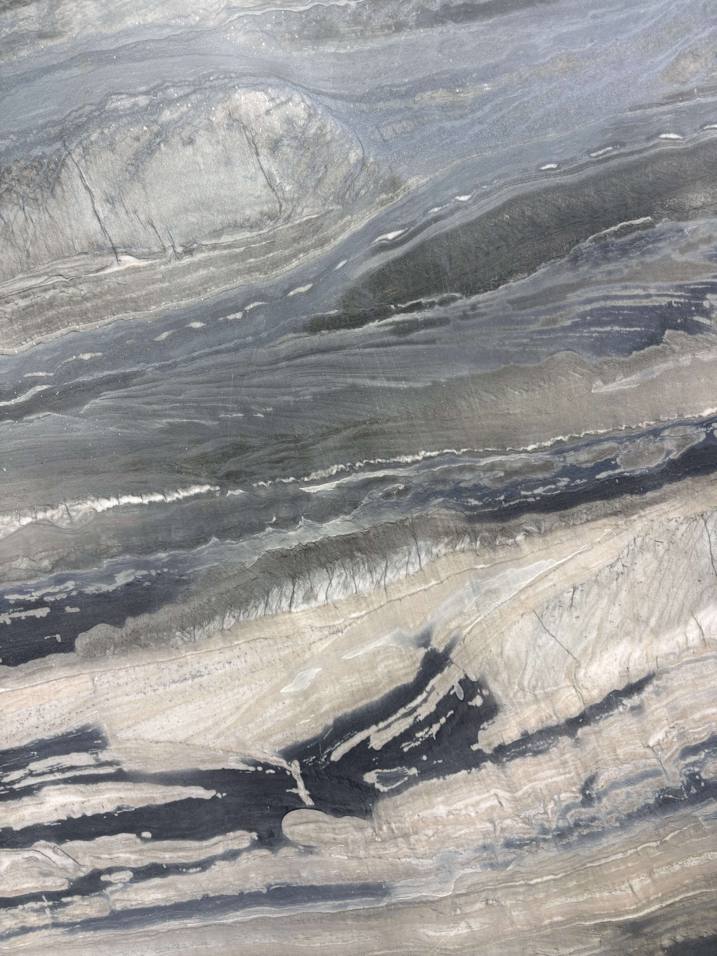 Galapagos quartzite detail, dark charcoal-grey striations with steel-grey and driftwood tones